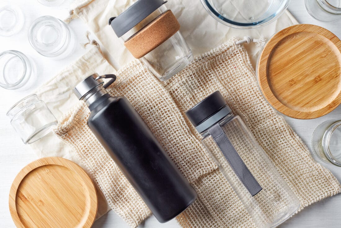 Zero waste concept, water bottles, coffe cup, glass storage containers and cotton bags, from above - JSB Designs Earth Day tips